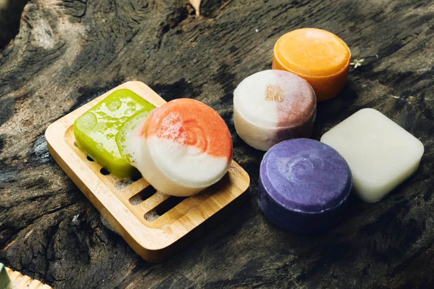 A lineup of colorful Eco Shift shampoo, conditioner and soap bars